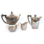 An Edwardian four-piece tea service of ovoid semi-fluted form, comprising a teapot, hot water jug,