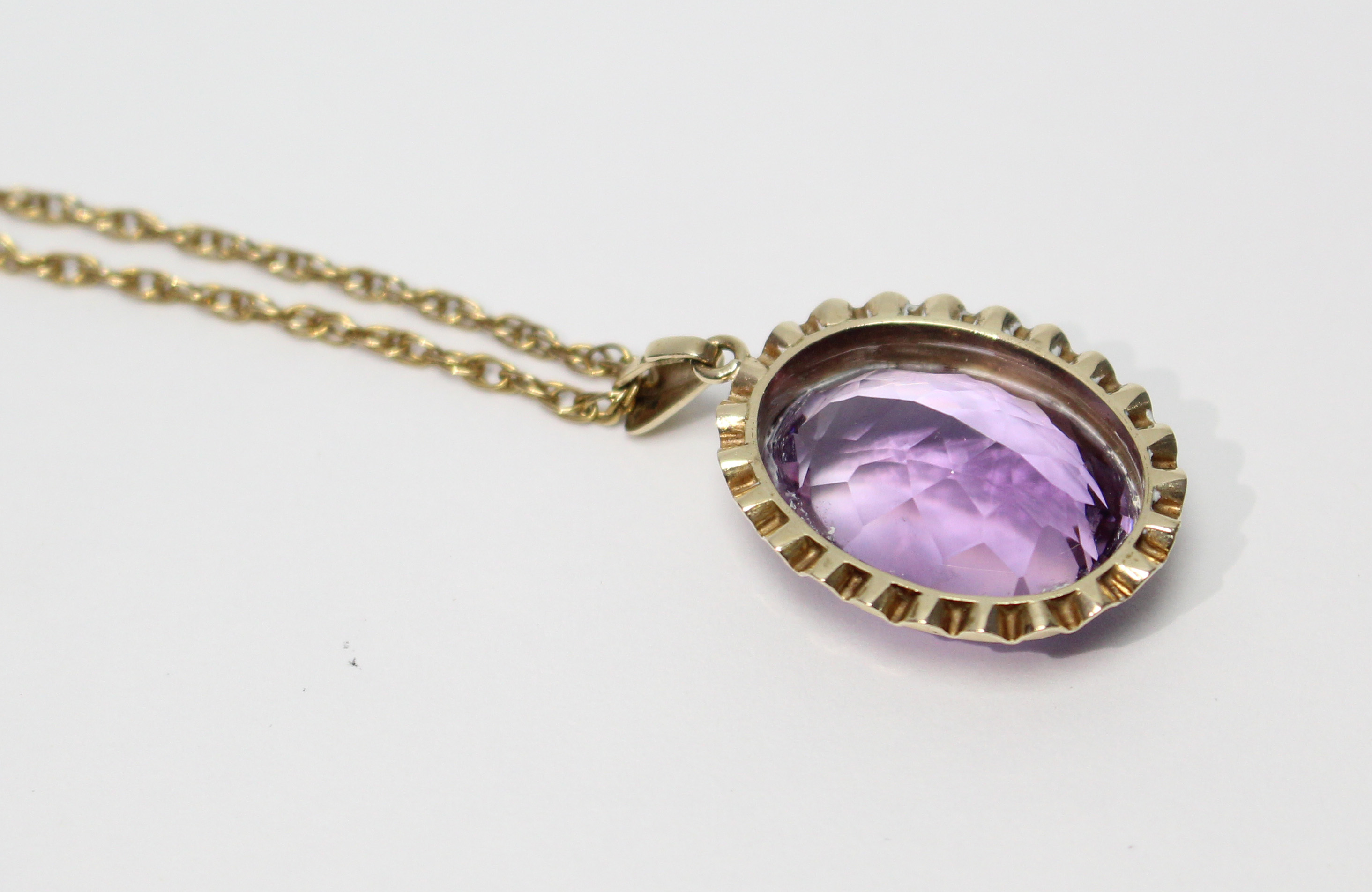 An oval-cut amethyst pendant in 9ct. gold mount, on yellow metal fine-link chain necklet. - Image 2 of 4