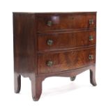 An early 19th century figured mahogany bow-front chest with crossbanded top, fitted three long