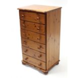 A pine inverted break-front upright chest, fitted six long drawers with turned knob handles, & on
