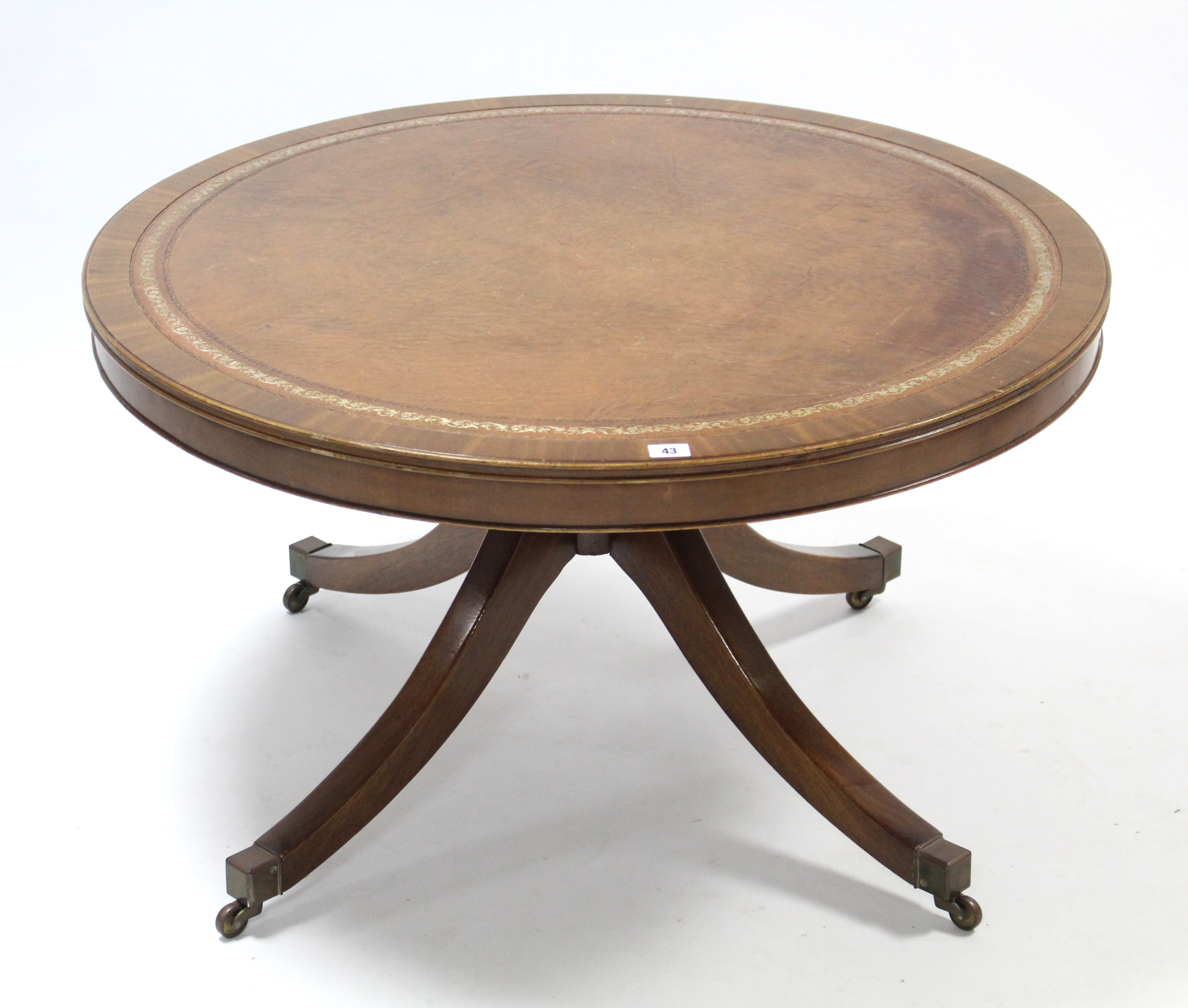 A reproduction mahogany low coffee table, inset gilt-tooled brown leather to the circular top, &