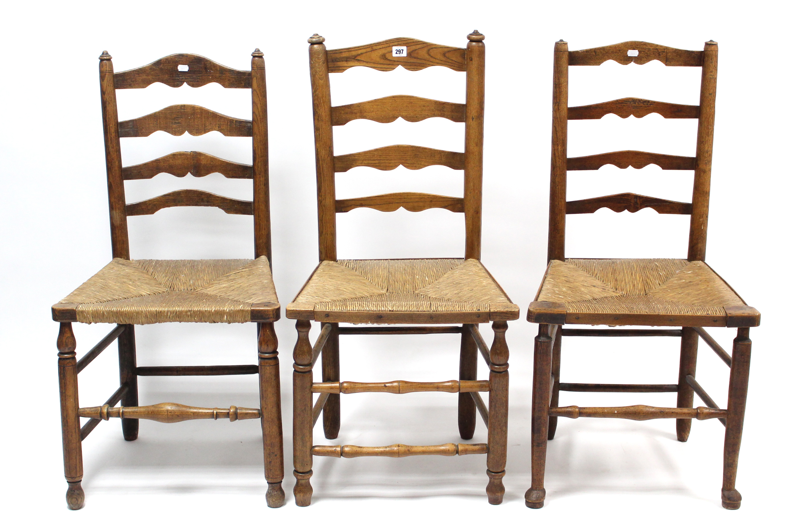 Three oak ladder-back dining chairs, each with woven-string seat, & on turned legs with turned