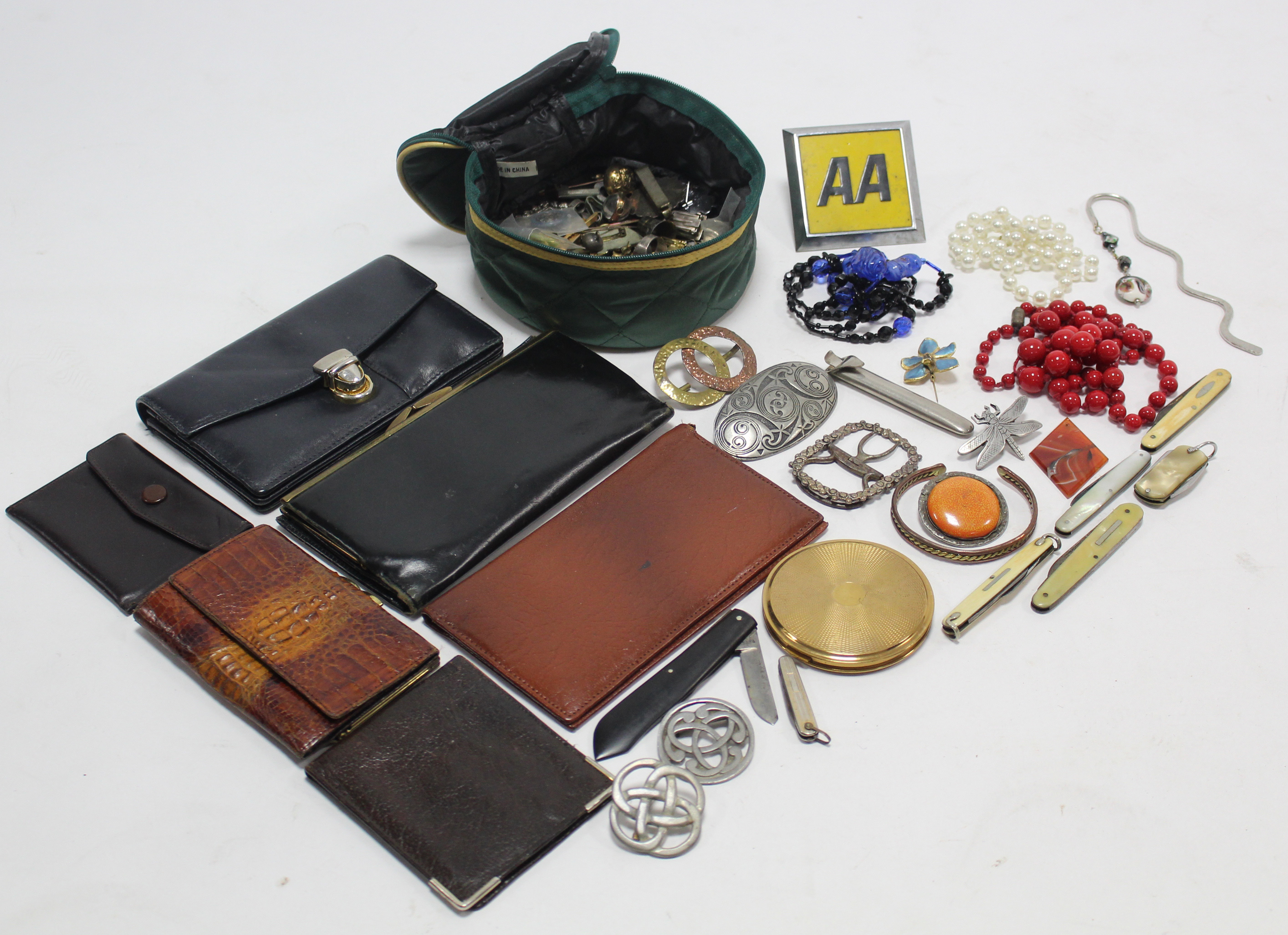 A gilt-metal compact; an “AA” car membership badge; five pocket knives; six purses; & various