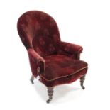 A late Victorian nursing chair, upholstered burgundy velour, & on short turned legs with ceramic