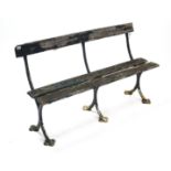 An early 20th century green painted teak slatted garden bench on cast-iron supports inscribed “C. H.