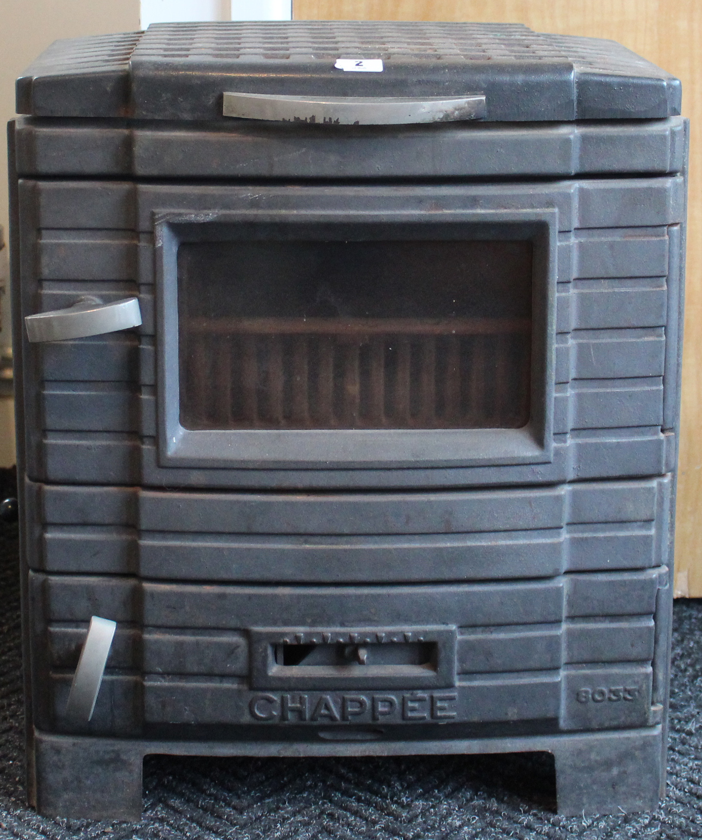 A Chappee wood-burning stove (No. 8033), in cast iron case, 19” wide x 22” high.