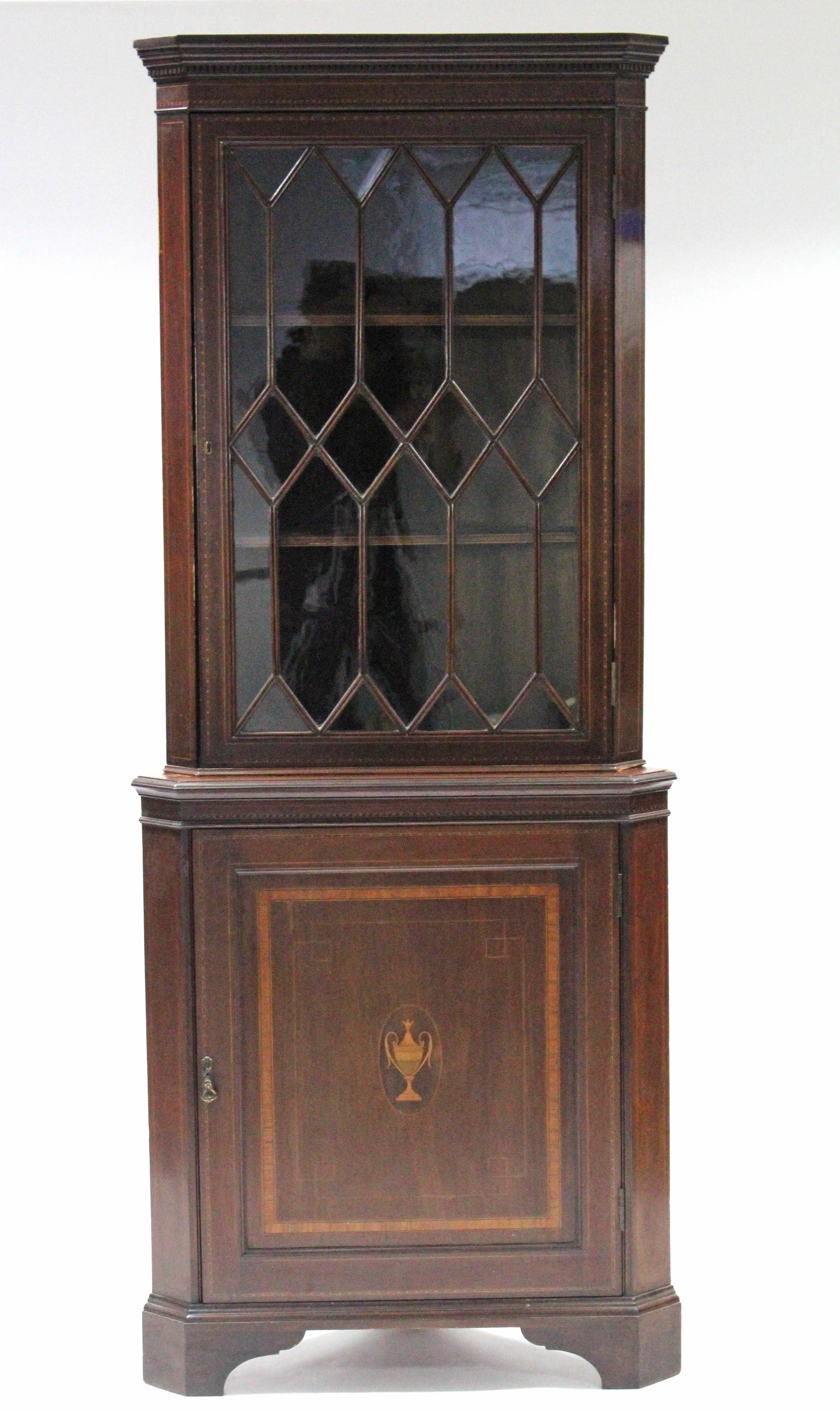 A 19th century inlaid-mahogany standing corner display cabinet with dentil cornice, fitted two