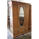 A pine wardrobe enclosed by oval bevelled mirror door to centre above a deep long drawer, & on