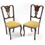 A pair of Edwardian marquetry-inlaid splat-back occasional chairs with sprung seats, & on slender