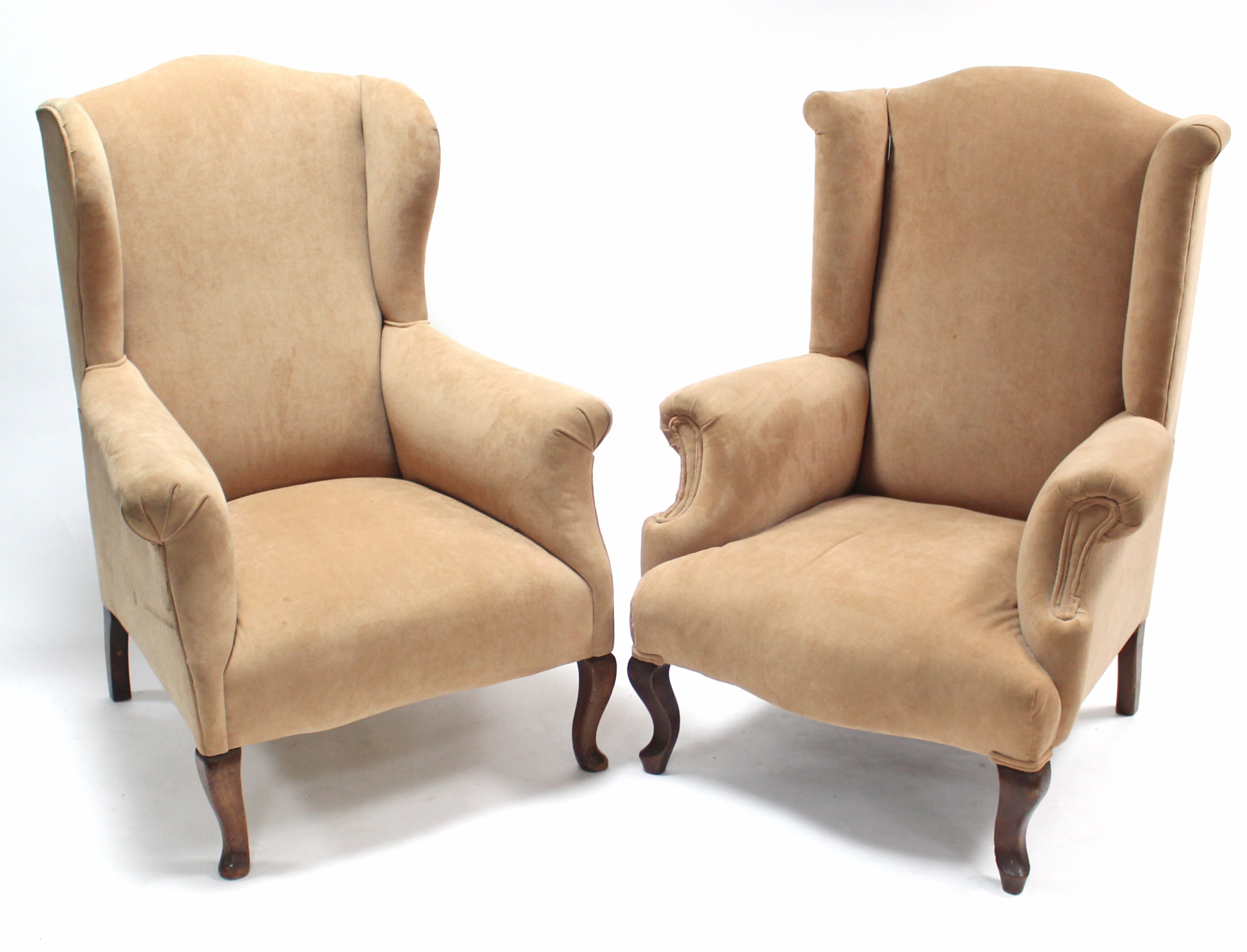 A pair of wing-back armchairs upholstered fawn velour, & on short cabriole legs.