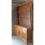 A reproduction oak large dresser, the upper part fitted two open shelves, the base fitted three