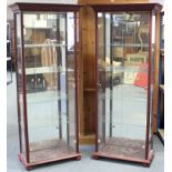A pair of mahogany-finish tall china display cabinets, each fitted four plate-glass shelves enclosed