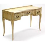 A continental-style cream painted wooden tray top serpentine-front dressing table fitted three