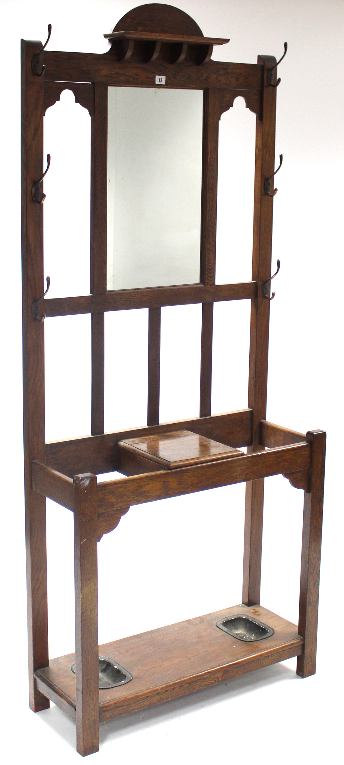 An Edwardian oak hallstand, inset rectangular mirror to back above glove compartment, & on square