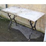 A wrought-iron garden table, with shaped end supports joined by plain centre stretchers & with white