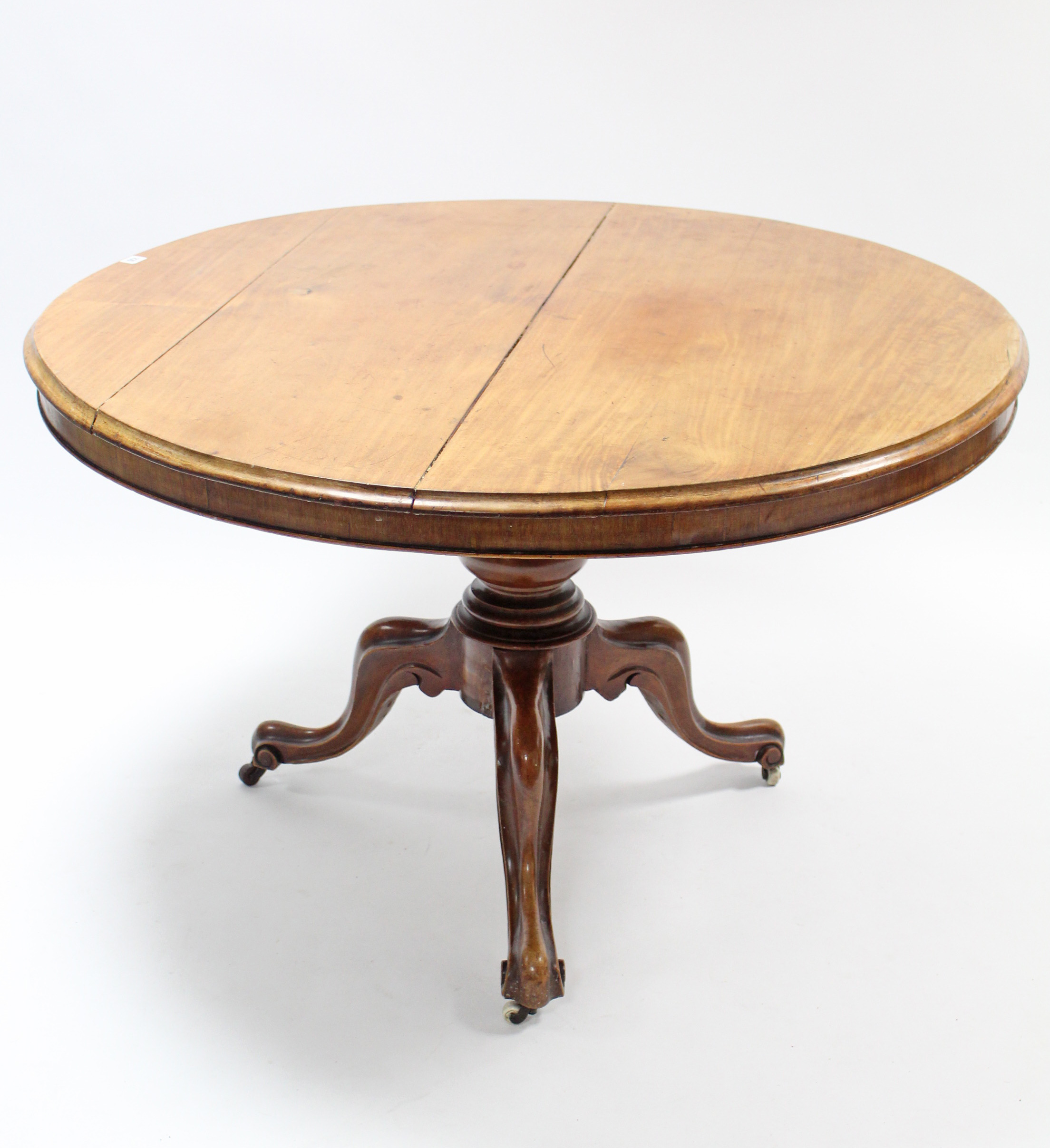 A Victorian mahogany loo table with circular tilt-top; & on vase turned centre column & three carved