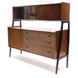 A 1970’s Nathan teak side cabinet fitted with an arrangement of cupboards, drawers, & shelves, &