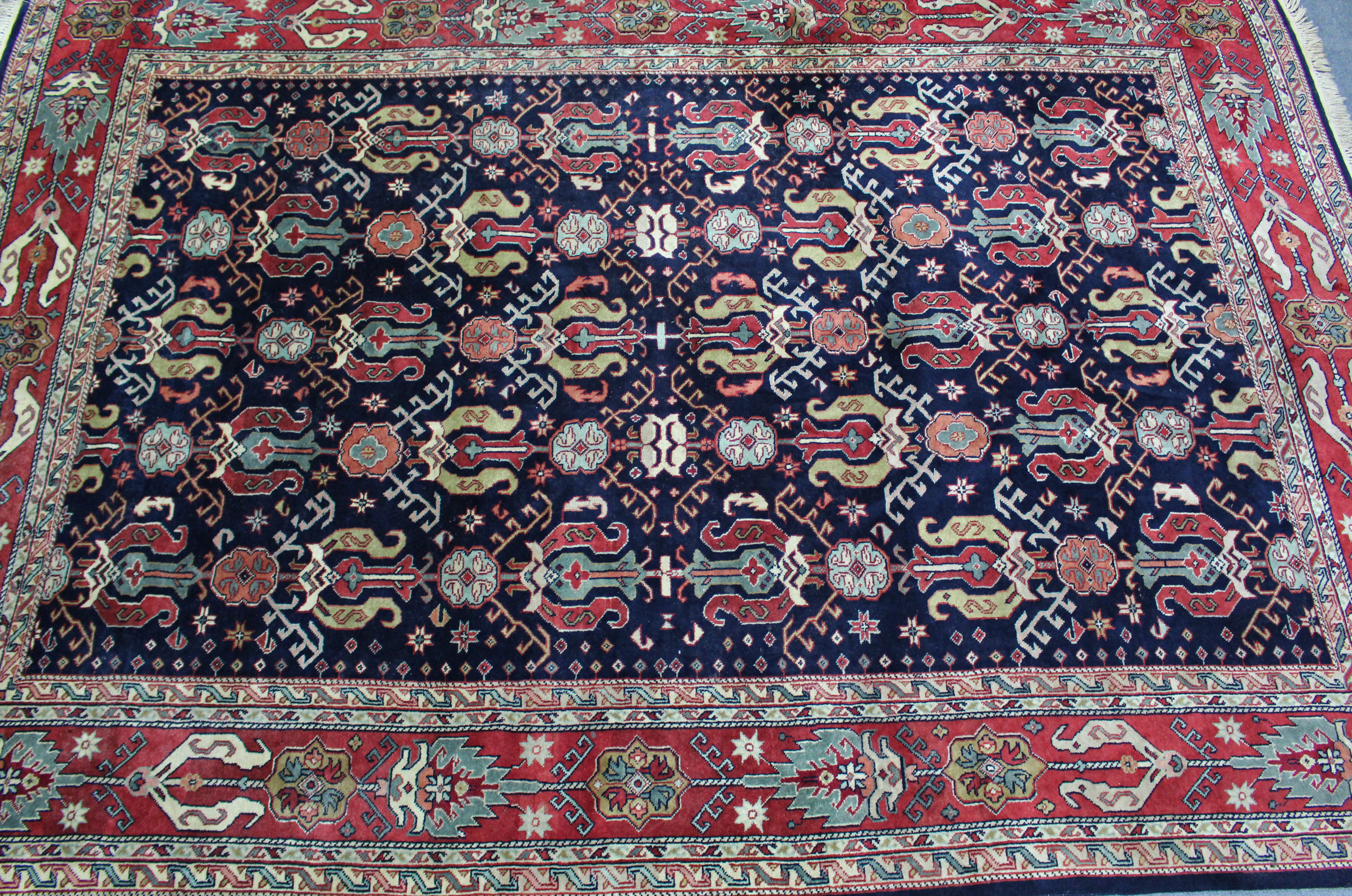 A Persian pattern carpet of crimson & ivory ground, with all-over repeating multi-coloured geometric