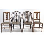 A pair of wheel back carver chairs with hard seats & on turned legs with spindle stretchers; & a