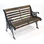 A teak slatted garden bench with green painted & pierced cast-iron end supports, 41½” long.