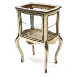 A continental cream painted wooden bijouterie table with gilt-metal mounts, enclosed by glazed door,
