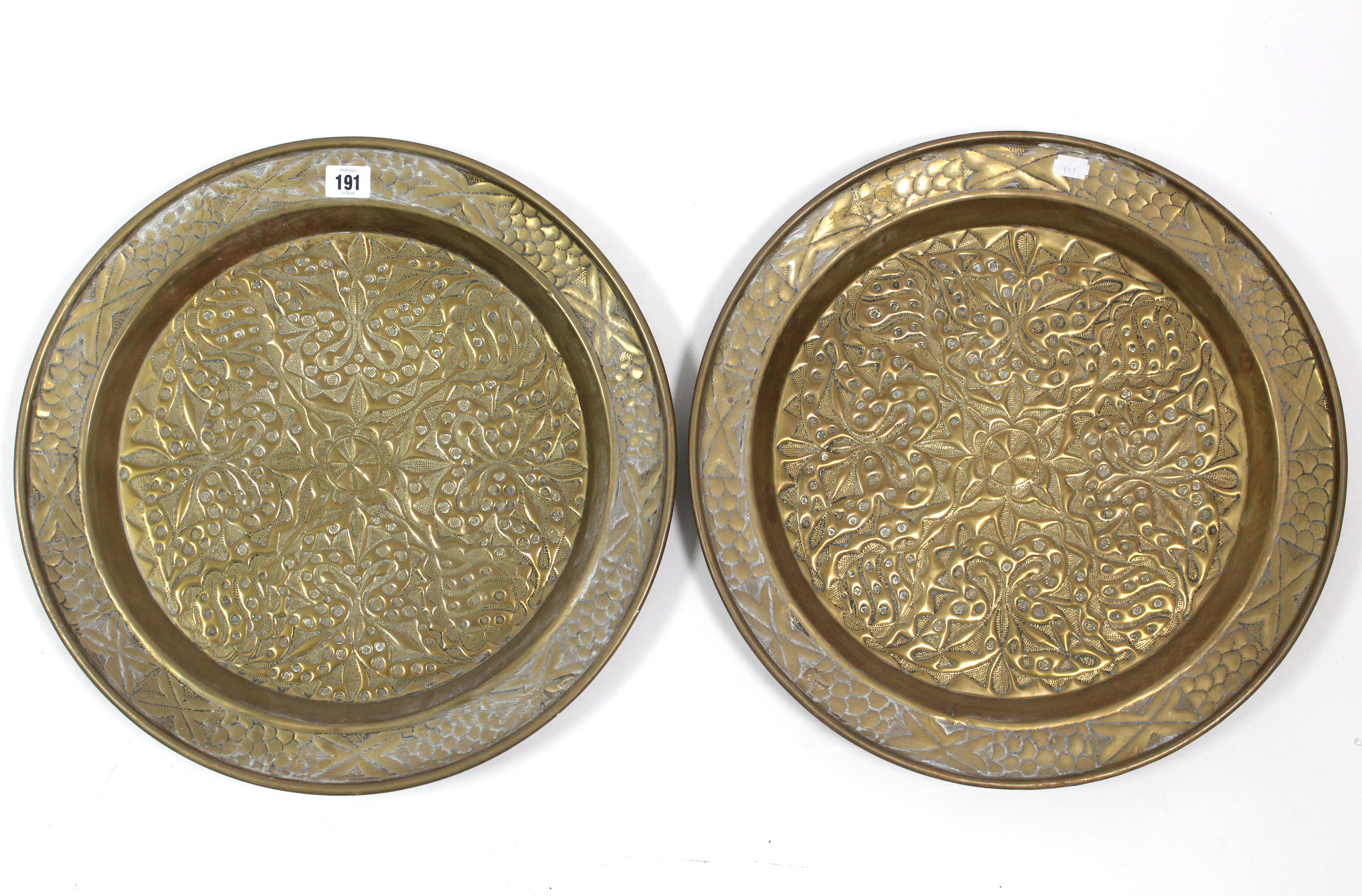 A pair of brass wriggle-work large circular dishes with all-over raised geometric design, 17¾”