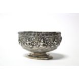 A Burmese silver sugar bowl with raised figure scene design & on octagonal pedestal foot, 4” diam. x