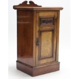 A late Victorian walnut bedside cupboard enclosed by carved panel door, & on plinth base, 16¾”