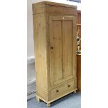 A late Victorian pine wardrobe enclosed by centre panel door above a long drawer, & on turned