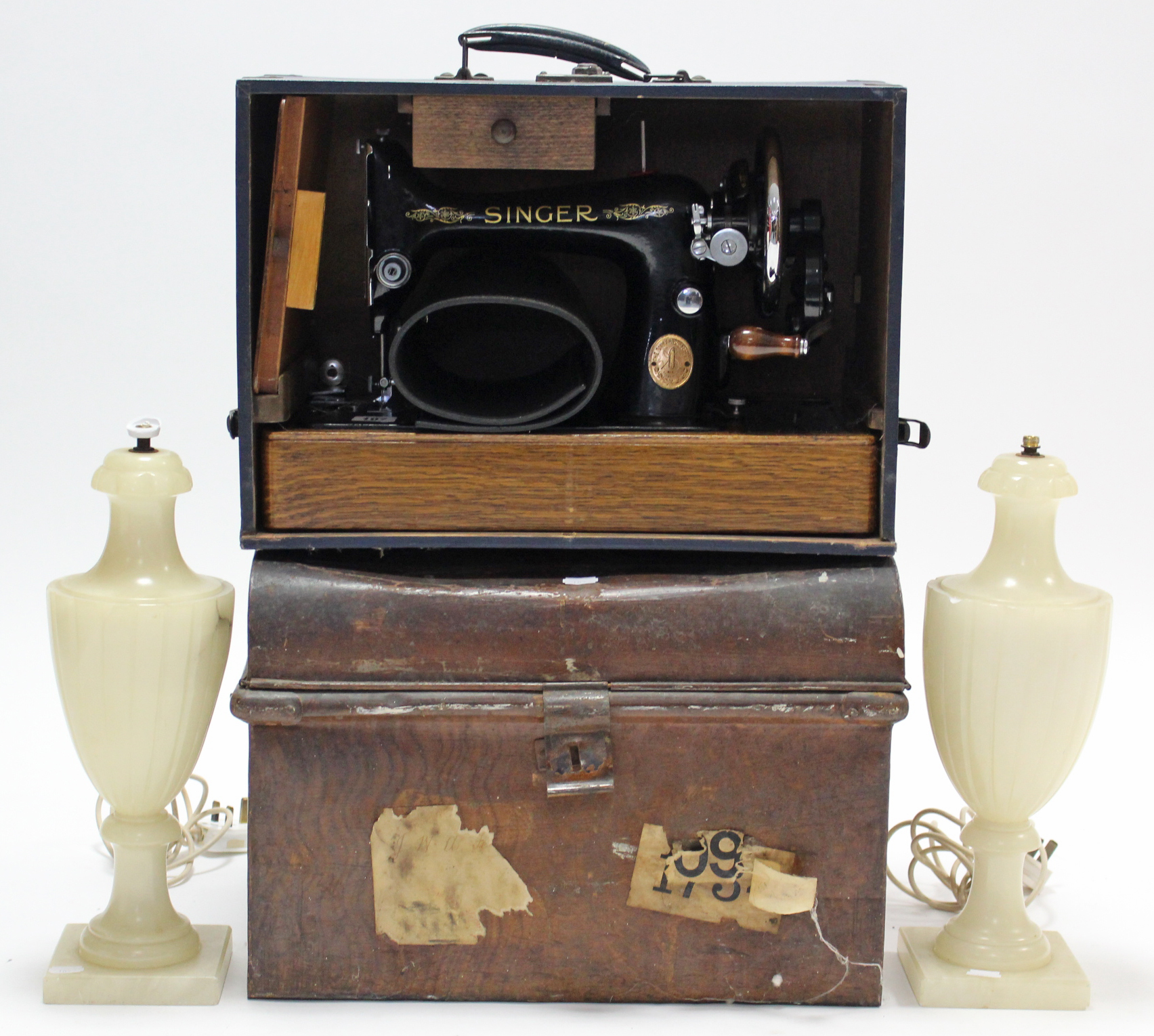 A Singer hand sewing machine with blue fibre-covered case; a grained tin domed-top trunk, 18”