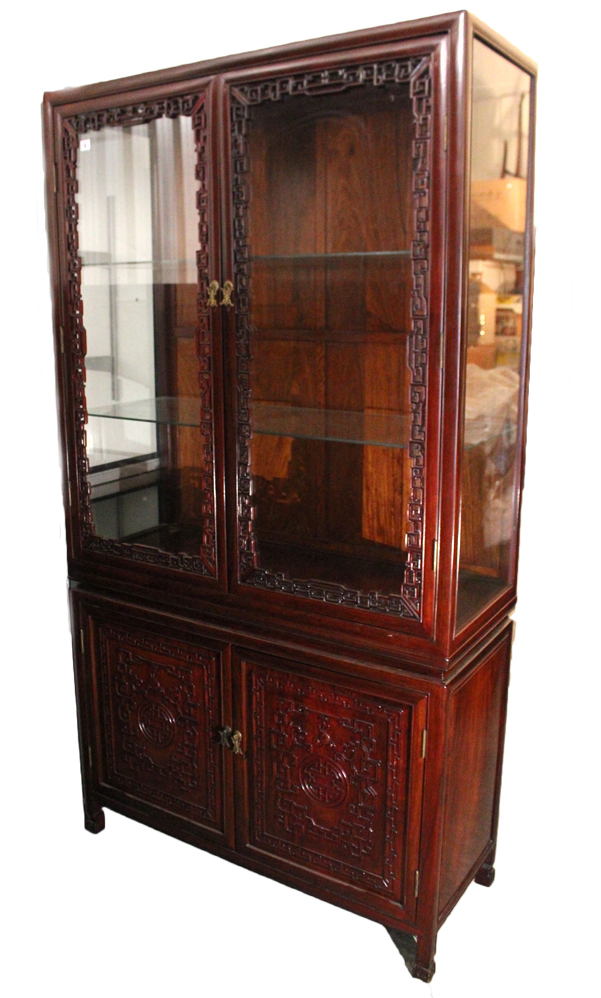 A Chinese carved hardwood tall china display cabinet, the upper part fitted two plate-glass