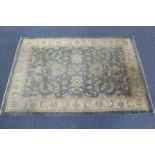 An eastern pattern rug of cream & grey ground, & with all-over repeating foliate design to centre