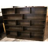 A large teak fifteen-division standing open bookcase on plinth base, 75½” long x 60” high.