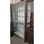 A silvered metal-frame & white laminate tall shop’s display cabinet, fitted four plate-glass shelves