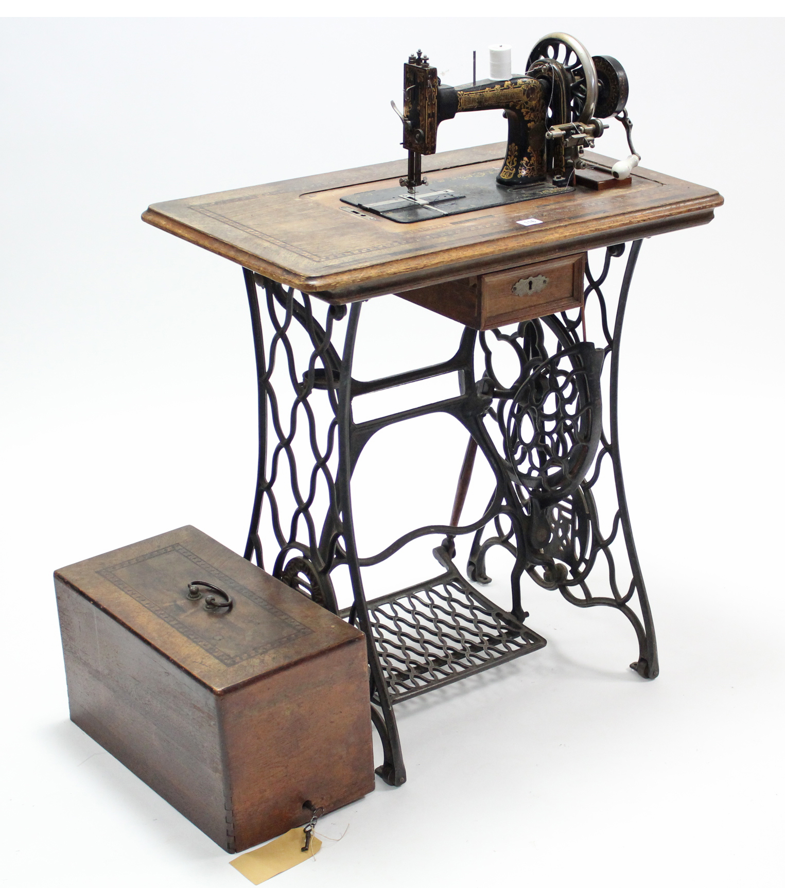 An early 20th century Frister & Rossmann treadle sewing machine in inlaid-walnut case, & on black