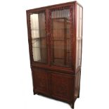 A Chinese carved hardwood tall china display cabinet, the upper part fitted two plate-glass