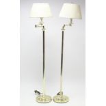 A pair of brass-finish standard lamps with adjustable arm & on circular base, with shades.