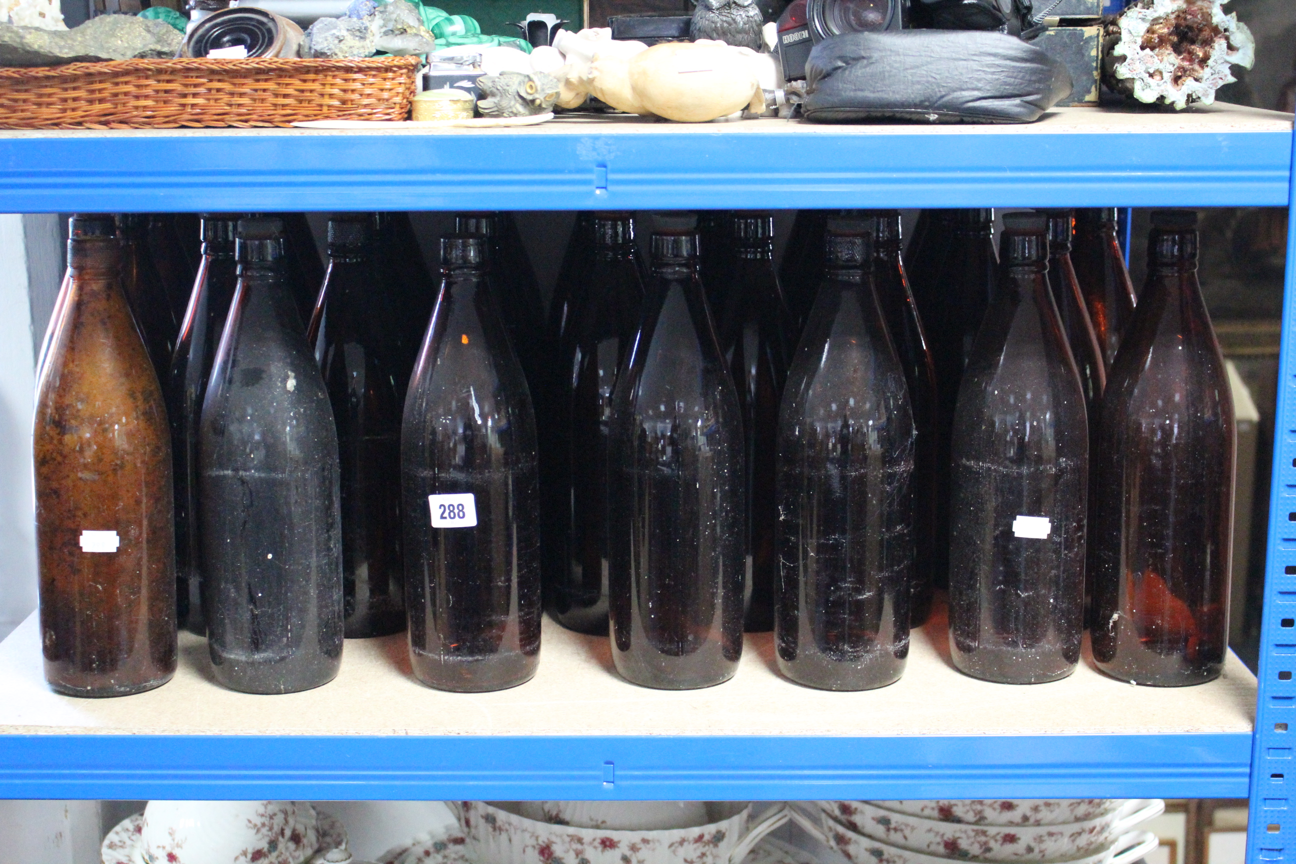 A collection of approximately thirty various amber tinted glass bottles.