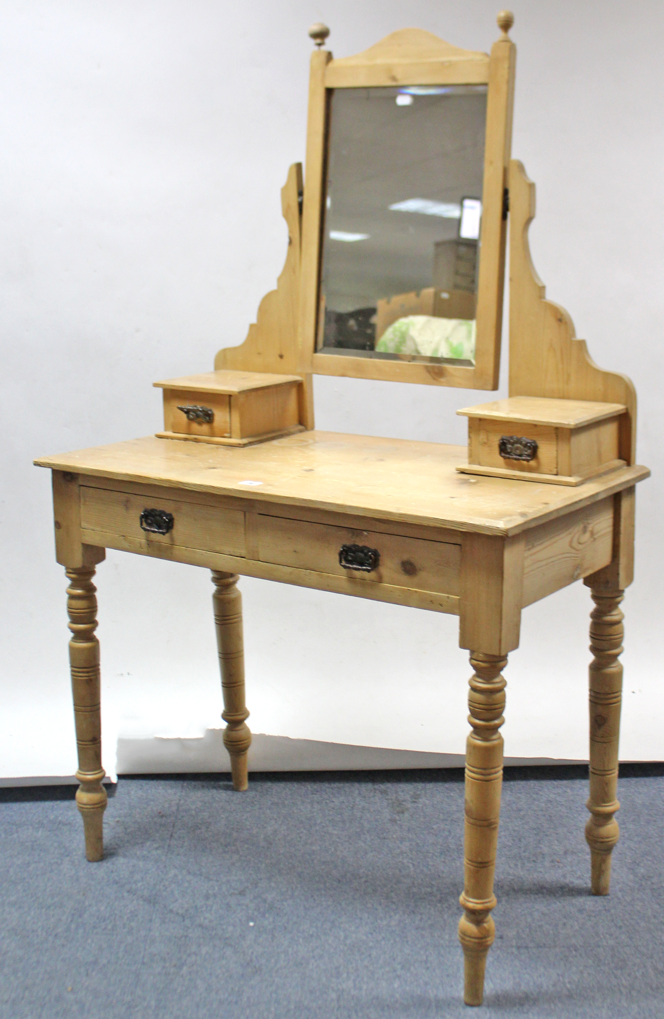 A late Victorian pine dressing table with rectangular bevelled swing mirror to the stage back,