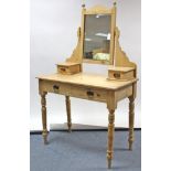 A late Victorian pine dressing table with rectangular bevelled swing mirror to the stage back,