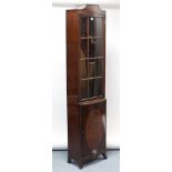 A mahogany tall cabinet of narrow proportions, fitted three shelves enclosed by glazed door above