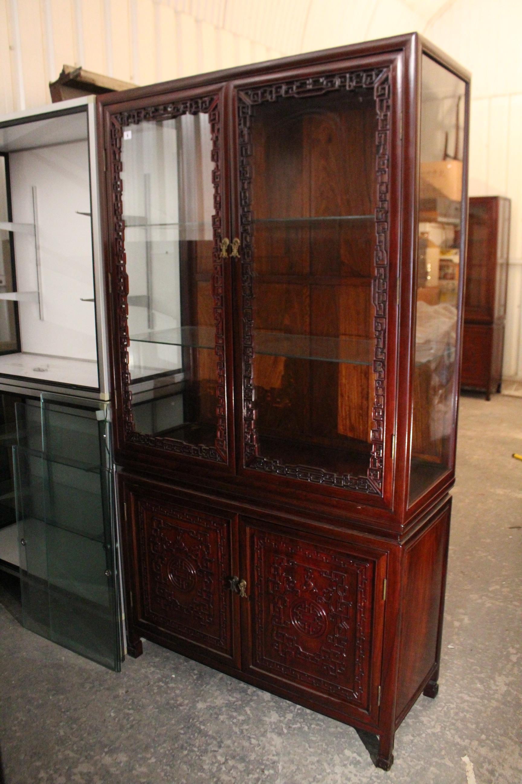 A Chinese carved hardwood tall china display cabinet, the upper part fitted two plate-glass - Image 2 of 2