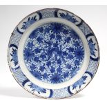 An 18th century Dutch delft charger painted in blue with a Chinese dragon amongst foliage to the