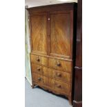 An early Victorian mahogany linen press, fitted four sliding trays enclosed by a pair of fielded