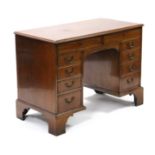 A George III mahogany kneehole writing desk, fitted two long & eight short graduated drawers with