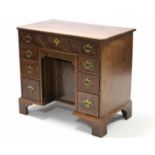 A George III style mahogany kneehole desk by Christopher Alexander, fitted an arrangement of seven