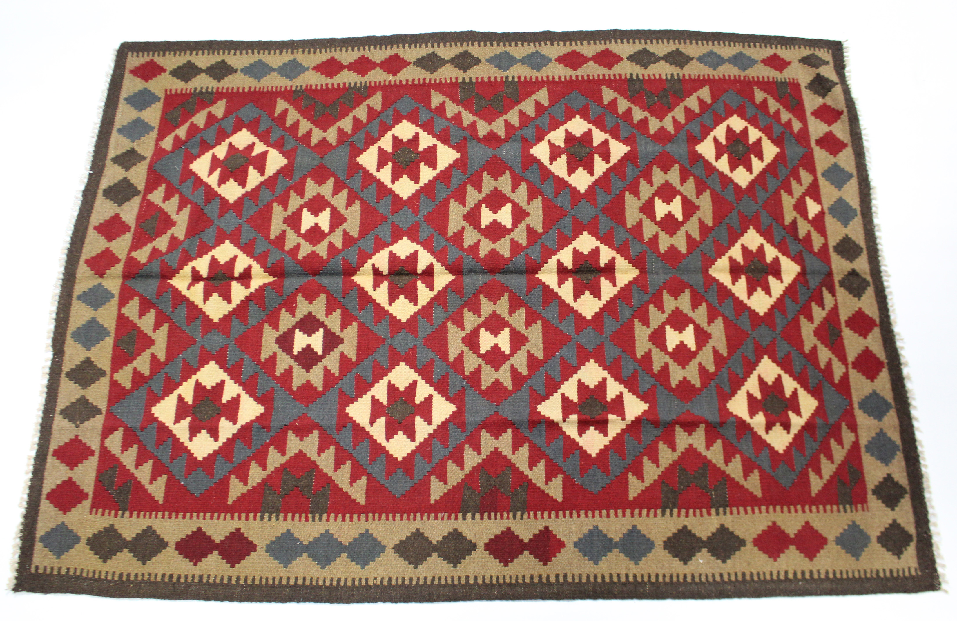 A Kelim rug of deep red ground with central panel of multicoloured lozenges within a geometric