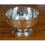 An Edwardian silver punch bowl with indented rim, the body decorated with raised strapwork, on round