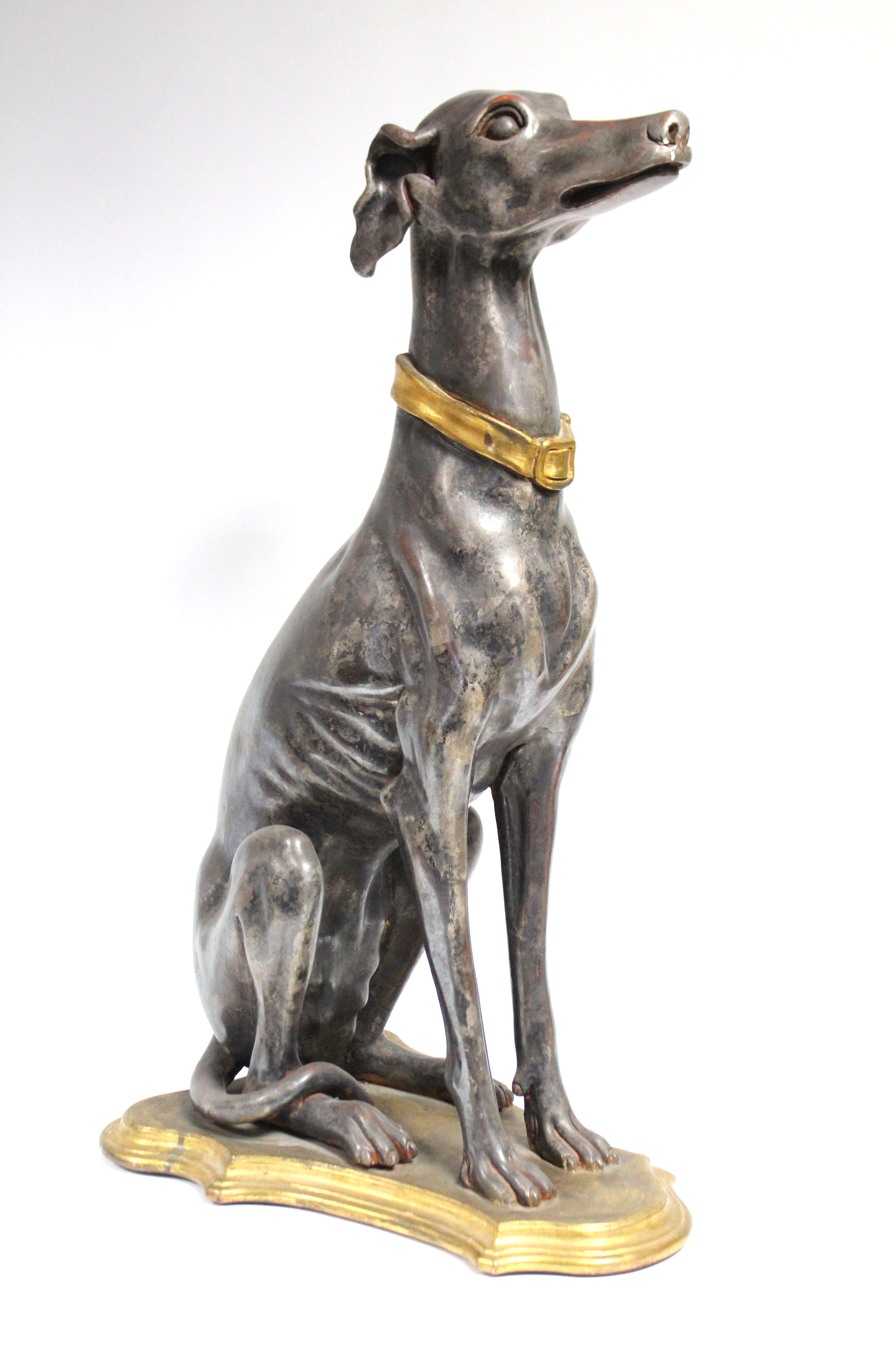 A painted composition model of a seated greyhound, on shaped plinth base; 30¼” high.