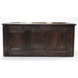 A late 17th century joined oak coffer, the triple-panel front with carved frieze dated 1684, the